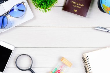 Taylandlı işçi ve çalışan masası, düz bir manzaradan beyaz ahşap masaya dizilmiş dizüstü bilgisayar, Tayland ve pasaportla seyahat etmeye ve seyahat etmeye hazırlanıyor..