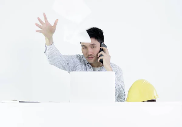 Asian employee engineer salary man sitting at desk throwing papers with feeling angry and upset, isolated on white background.