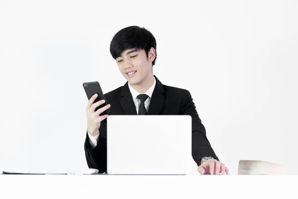 아시아의 매니저 사업가가 책상에 앉아서 전화기를 사용하며 배경에 고립되어 있습니다 — 스톡 사진