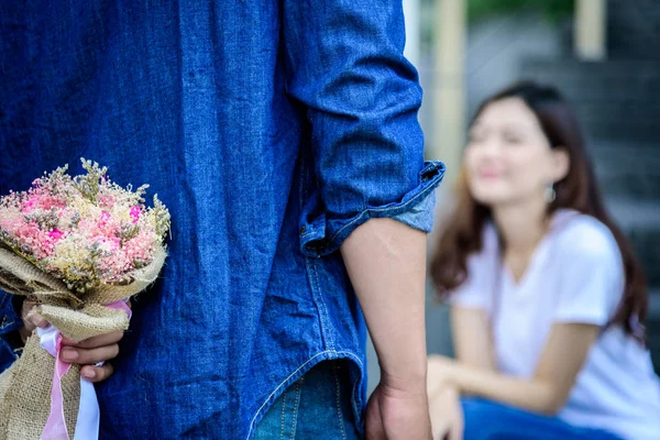 アジアの男は彼女にお詫びとお詫びを言うために花を準備して待っています — ストック写真