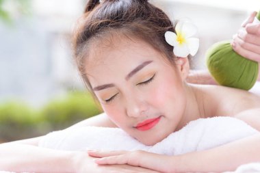Güzel Asyalı insanların portresi. Kapalı görüşlü, gözlerini kapatan ve kaplıca salonunda el masajı yaptıran. Güzellik, sağlık, kaplıca ve rahatlama konsepti.