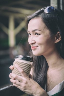 Asyalı kadın gezgin, Bangkok, Tayland 'daki Hua Lamphong istasyonunda mutlulukla kahve içiyor..