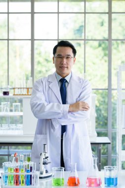 Laboratuvarda deney tüpleriyle çalışan Asyalı bir bilim adamı..