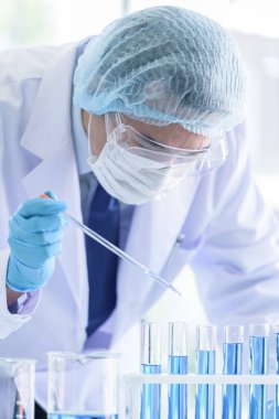 Asyalı bilim adamı ekibi laboratuvarda araştırma yapıyor..