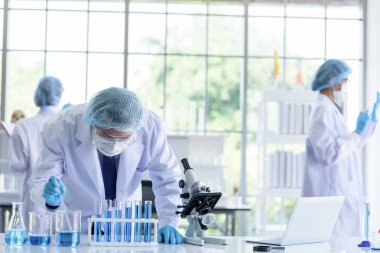 Asyalı bilim adamı ekibi laboratuvarda araştırma yapıyor..