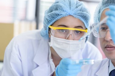 Asyalı bilim adamı ekibi laboratuvarda araştırma yapıyor..