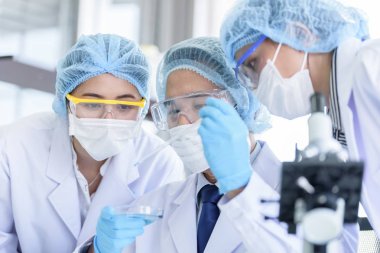 Asyalı bilim adamı ekibi laboratuvarda araştırma yapıyor..