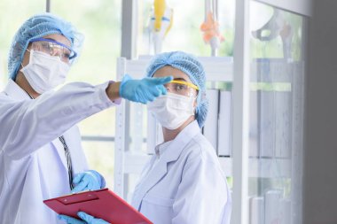Asyalı bilim adamı ekibi laboratuvarda araştırma yapıyor..