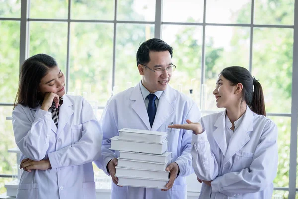上級アジアの科学者は、研究室の学生に新しい仕事を割り当てます — ストック写真