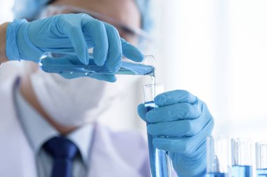 Asyalı bilim adamı bir laboratuvarda araştırma ve öğrenme yapıyor..