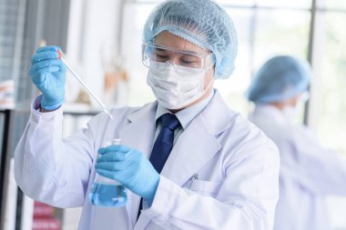 Asyalı bilim adamı ekibi laboratuvarda araştırma yapıyor..