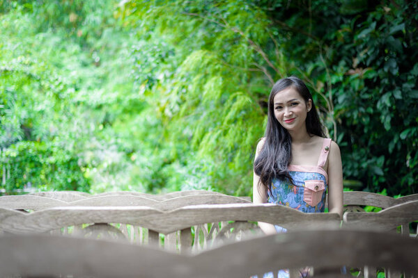 Asian pretty girl has sitting with happy and relaxing at Little Tree Garden cafe, Nakhon Pathom province, Thailand in the morning.