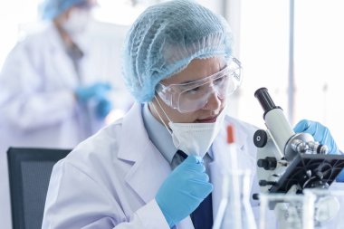Asyalı bilim adamı ekibi laboratuvarda araştırma yapıyor..