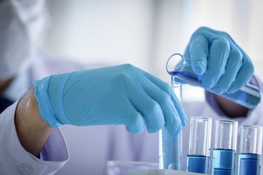 Asyalı bilim adamı bir laboratuvarda araştırma ve öğrenme yapıyor..