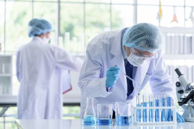 Asyalı bilim adamı ekibi laboratuvarda araştırma yapıyor..