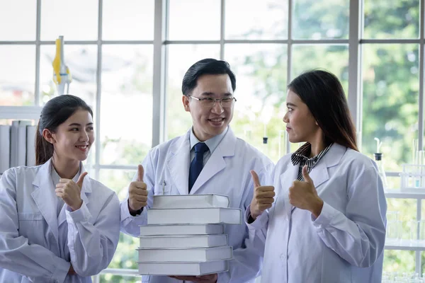 Senior asiatique scientifique a assigner un nouvel emploi pour les étudiants en laboratoire — Photo