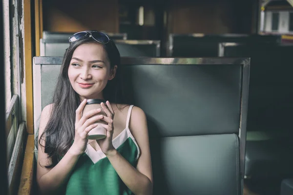 Asiatico donna viaggiatore ha bere caffè in il treno con happi — Foto Stock