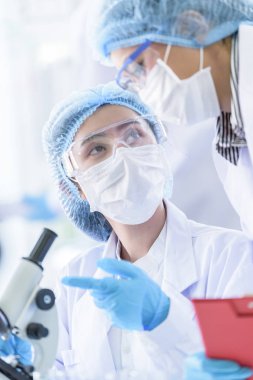 Asyalı bilim adamı ekibi laboratuvarda araştırma yapıyor..