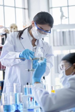 Asyalı bilim adamı ekibi laboratuvarda araştırma yapıyor..