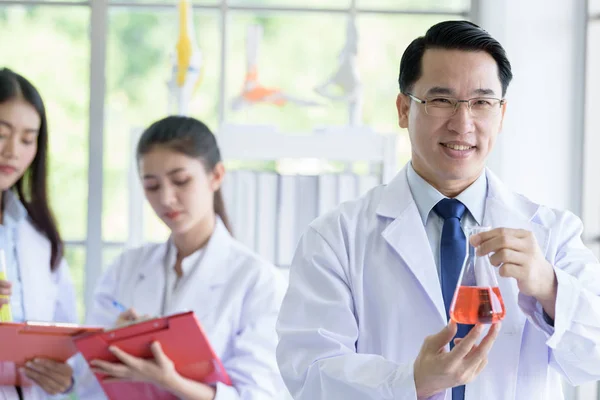 Hombre científico de laboratorio asiático que trabaja en el laboratorio con asiáticas. — Foto de Stock