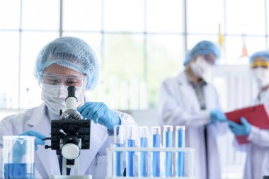 Asyalı bilim adamı ekibi laboratuvarda araştırma yapıyor..