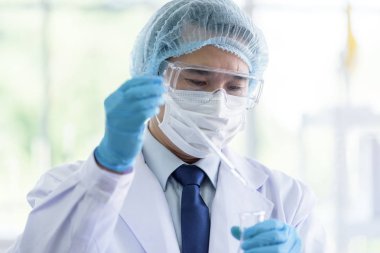 Asyalı bilim adamı laboratuvarda araştırma yapıyor..