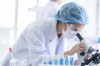 Asyalı bilim adamı ekibi laboratuvarda araştırma yapıyor..