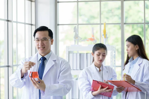 Hombre científico de laboratorio asiático que trabaja en el laboratorio con asiáticas. — Foto de Stock