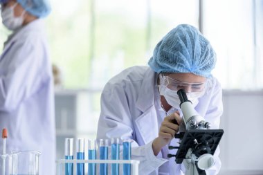Asyalı bilim adamı ekibi laboratuvarda araştırma yapıyor..
