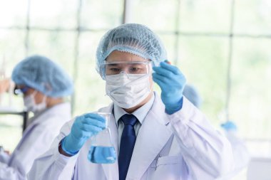 Asyalı bilim adamı ekibi laboratuvarda araştırma yapıyor..
