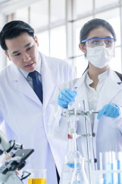 Asyalı bilim adamı ekibi laboratuvarda araştırma yapıyor..