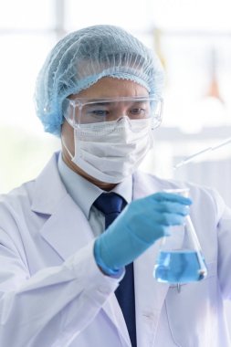 Asyalı bilim adamı laboratuvarda araştırma yapıyor..