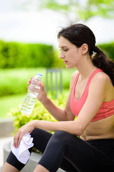 Belle coureuse a fatigué et se reposer pour l'eau potable et — Photo