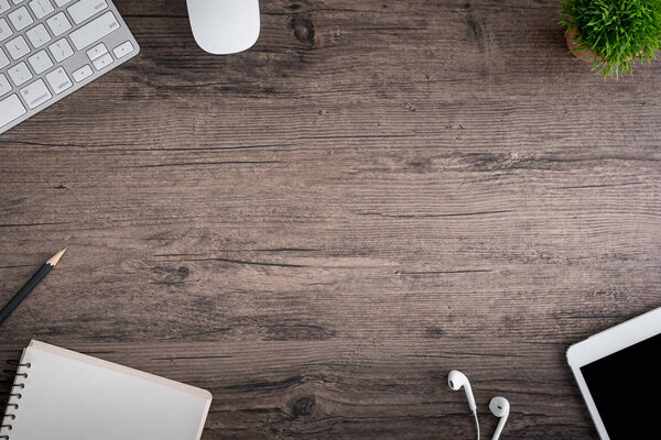 С офисного стола открывается вид на клавиатуру, мышь, дерево, книгу, 