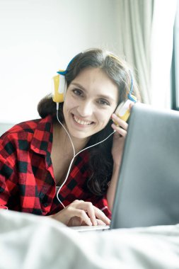 Bilgisayarda çalışan ve müzik dinleyen güzel bir kadın. 