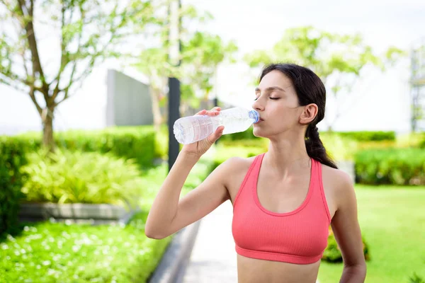 Hermosa mujer corredor tiene agua potable en el jardín.. —  Fotos de Stock