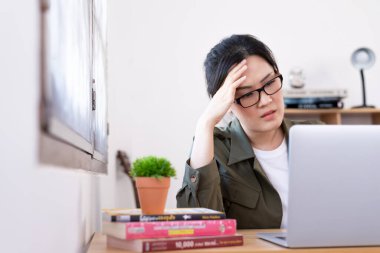 Modern Asyalı kadın üzgün ve mutsuz bir şekilde evden çalışıyor..