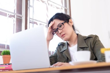 Modern Asyalı kadın üzgün ve mutsuz bir şekilde evden çalışıyor..