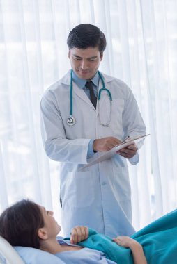 Hastanedeki ya da klinikteki hasta kadınla ilgilenen bir doktor..