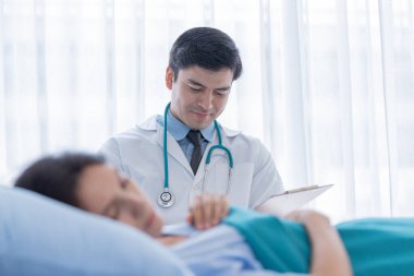 Hastanedeki ya da klinikteki hasta kadınla ilgilenen bir doktor..