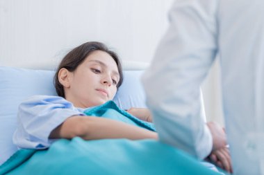 Bir doktor, hastanede ya da klinikte üzgün ve mutsuz olan hasta bir kadına bakar..