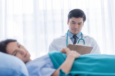 Hastanedeki ya da klinikteki hasta kadınla ilgilenen bir doktor..