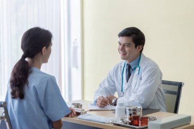 Hastanedeki ya da klinikteki hasta kadınla ilgilenen bir doktor..