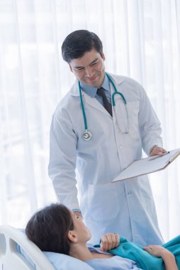 Hastanedeki ya da klinikteki hasta kadınla ilgilenen bir doktor..