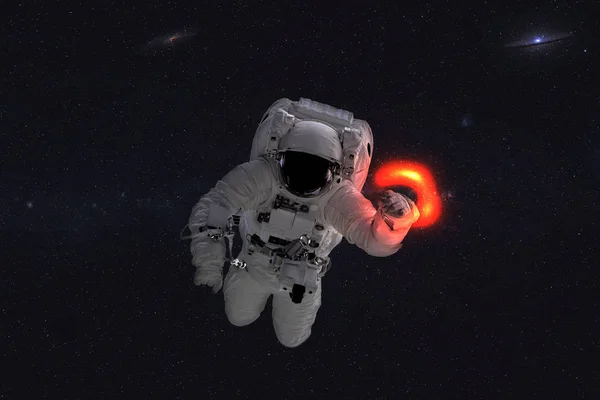 Space astronaut near black hole red glow.