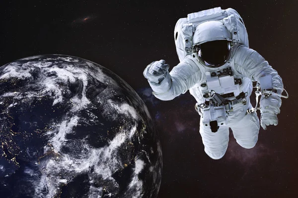 Космонавт в открытом космосе вблизи ночной Земли — стоковое фото