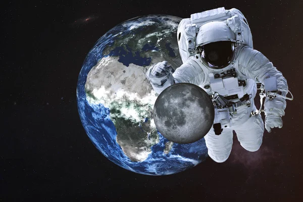 Giant astronaut near Earth planet with Moon — Stock Photo, Image