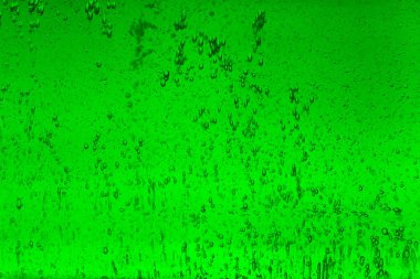 Yeşil sıvı arka plan dokusunda yüzen kabarcıklar.