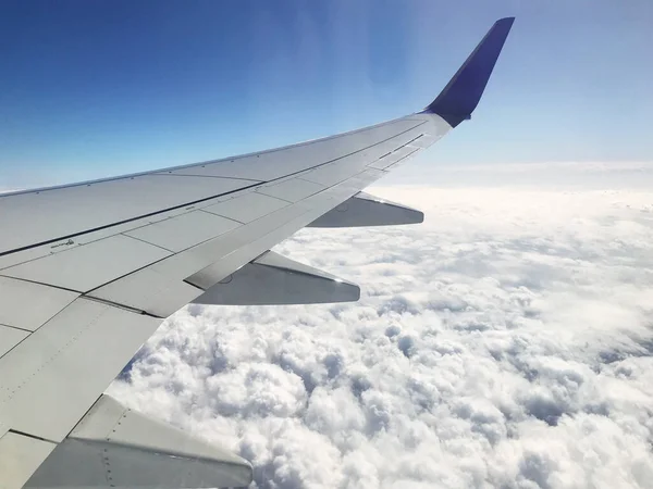 Zicht vanuit vliegtuig illuiminator aan de vleugel, bewolkte lucht. — Stockfoto