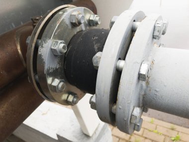 Endüstriyel üretim hattında çatlaklar olan eski gri boyalı kauçuk genişletme eklentisi.